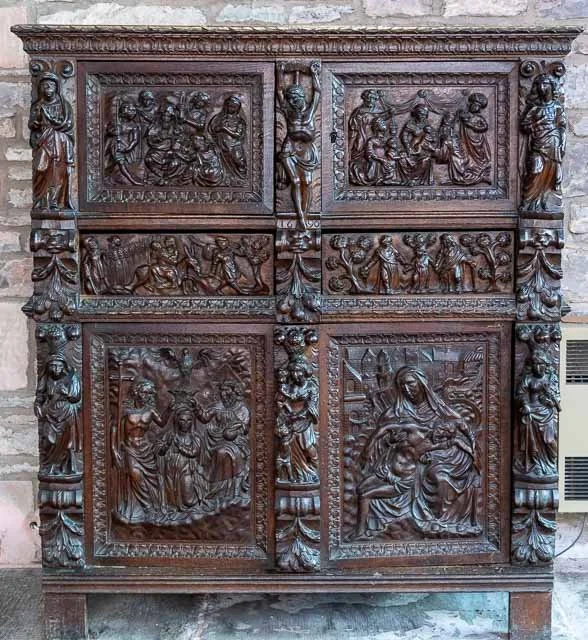 Intricately carved wooden religious altar with scenes from the Bible and statues of saints.