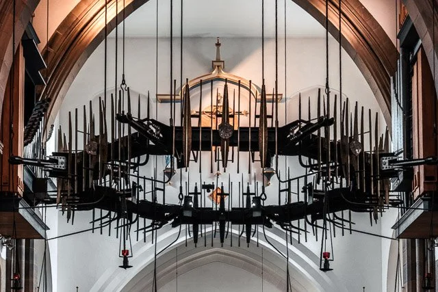 Large mechanical clock mechanism with gears and levers inside a church or cathedral