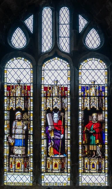 Stained glass window featuring three medieval kings holding scepters and wearing crowns.
