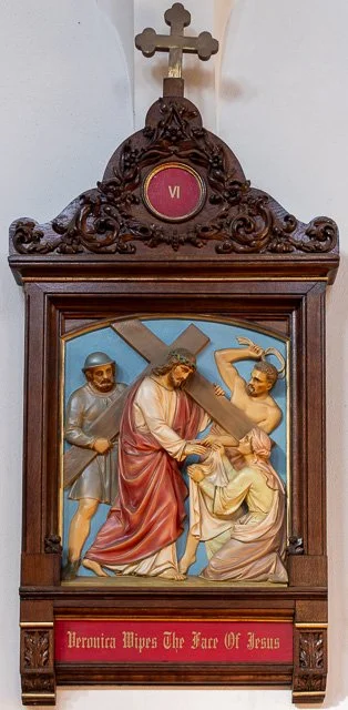 Religious wooden icon depicting Jesus Christ carrying the cross, accompanied by two soldiers, with a cross on top and an inscription at the bottom.