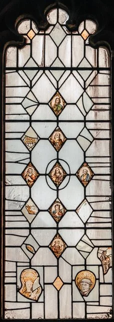 Stained glass window with religious figures and symbols.