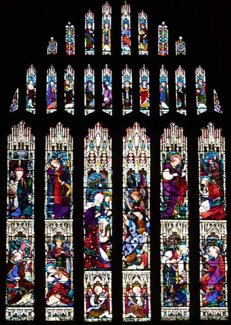 Colorful stained glass church window depicting religious scenes and figures.