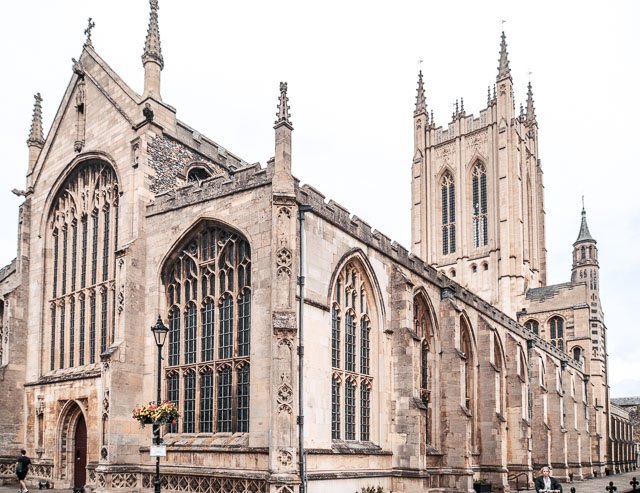 Exterior of a historic Gothic-style church with large stained-glass windows and tall towers.