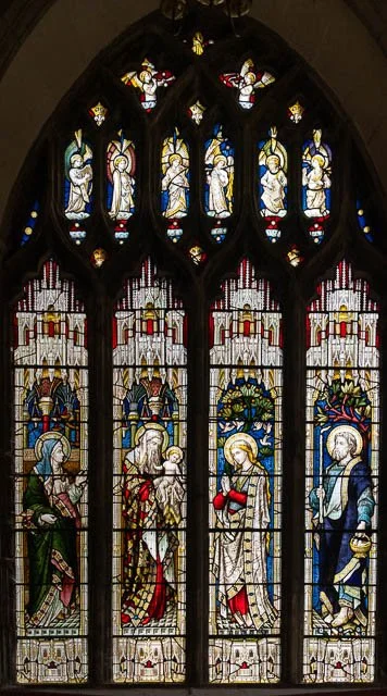Stained glass church window depicting biblical figures and angels.