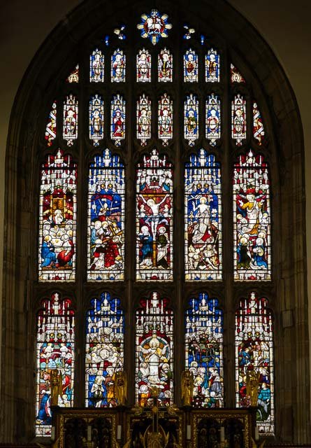 Colorful stained glass window depicting religious scenes and figures inside a church.