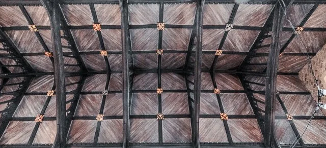 View of the underside of a wooden garage door with black metal support beams and decorative hardware.