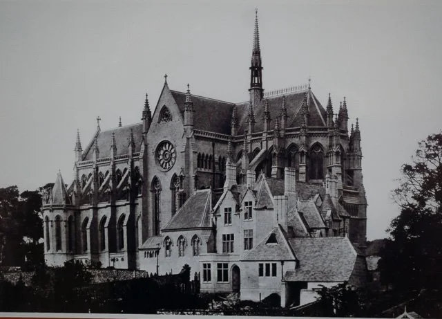 Black and white photo of a large, historic Gothic-style cathedral with intricate architectural details and a tall spire.
