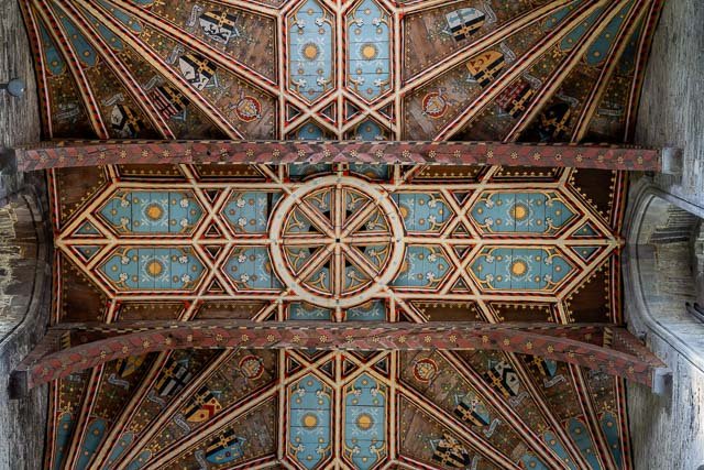 Colorful vaulted ceiling with intricate geometric patterns, painted in shades of blue, gold, and red.
