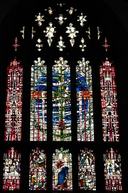 Colorful stained glass church window depicting biblical scenes and figures.
