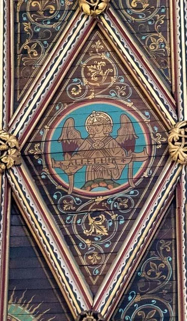 Ornate ceiling with religious artwork, featuring an angel holding a banner with the word "ALLELUIA," surrounded by decorative gold and floral patterns.