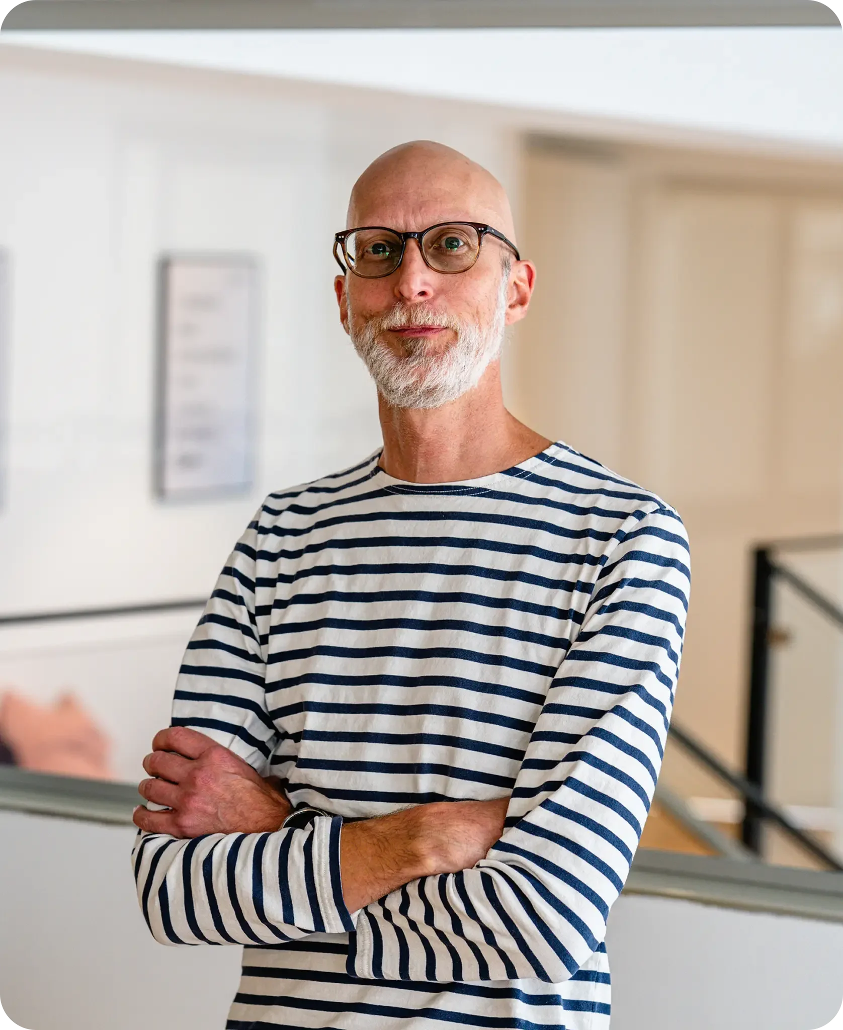 Bald man with glasses wearing a suit.