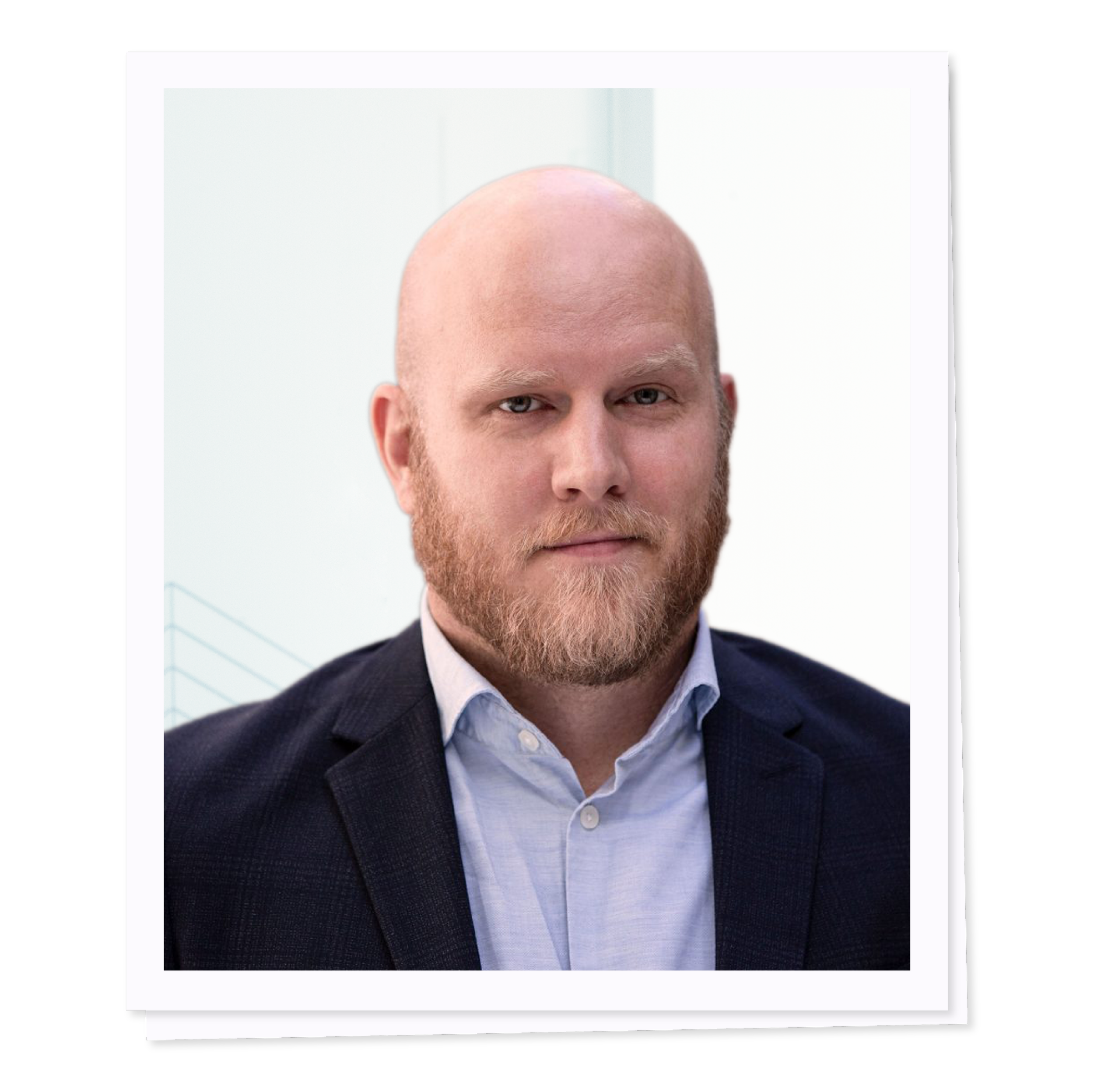 Bald man with beard wearing a suit and shirt, looking at the camera.