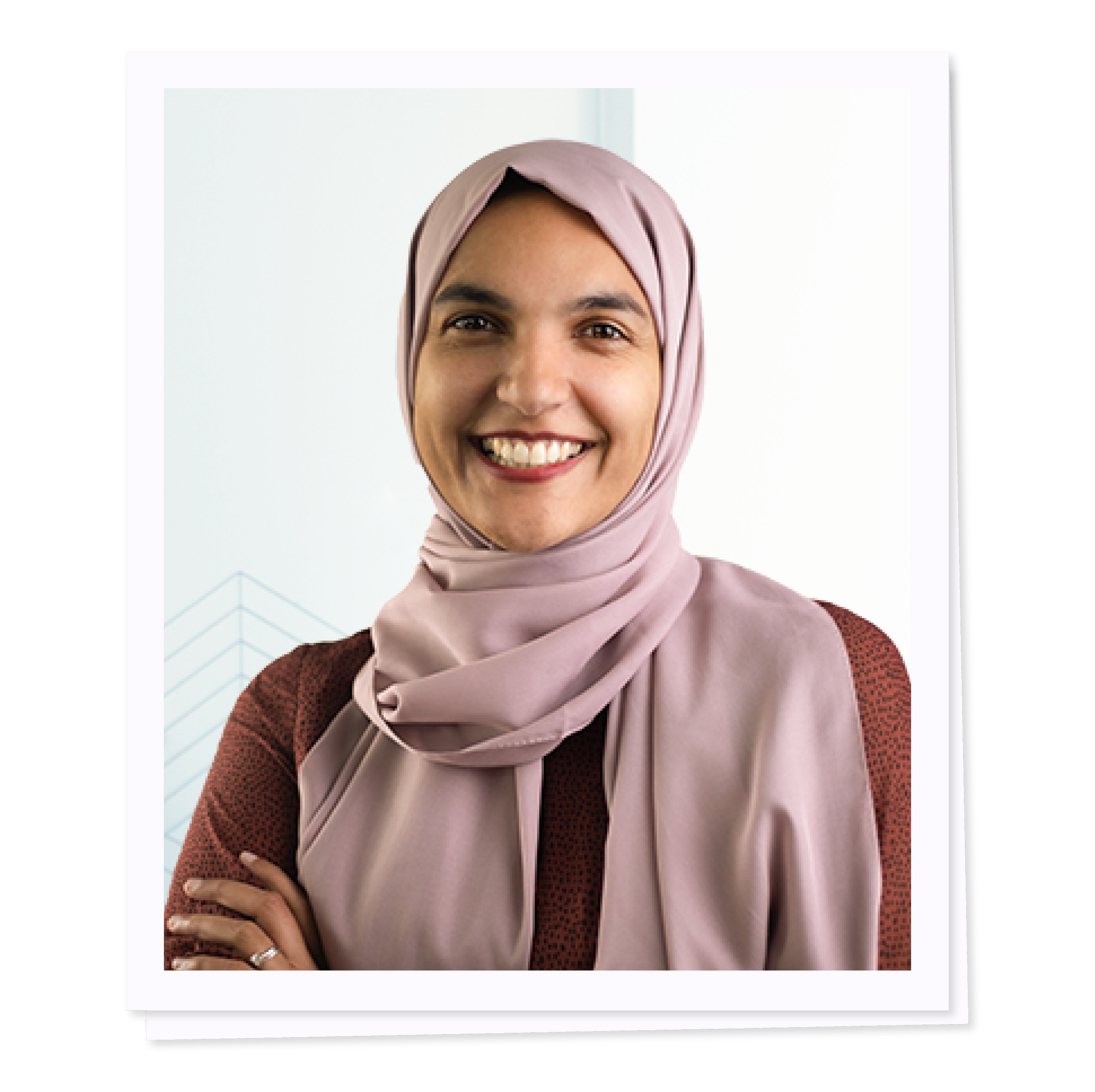 Smiling person wearing a hijab and a long-sleeve top, with arms crossed.