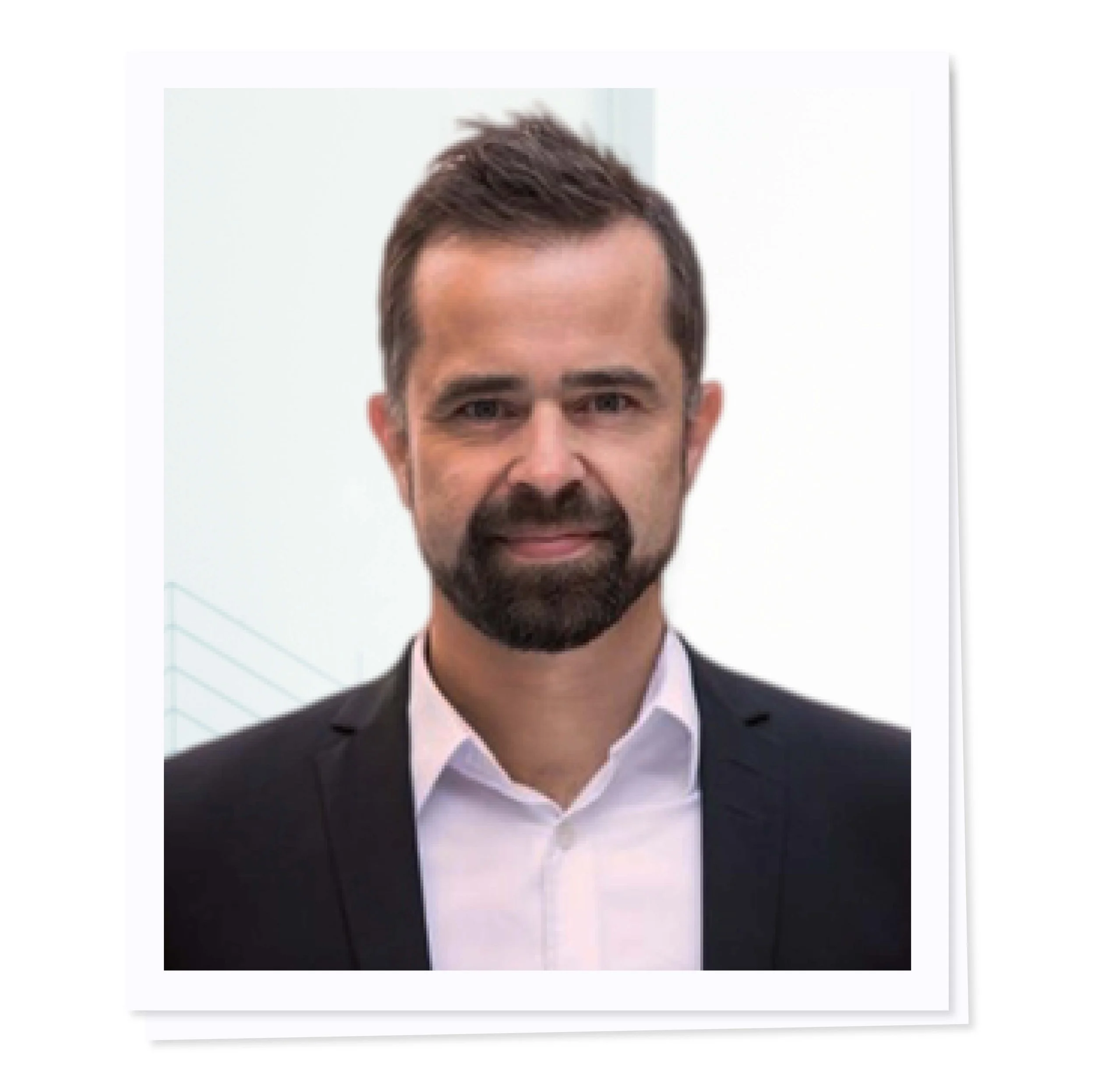 Portrait of a man in a suit with a beard and short hair.