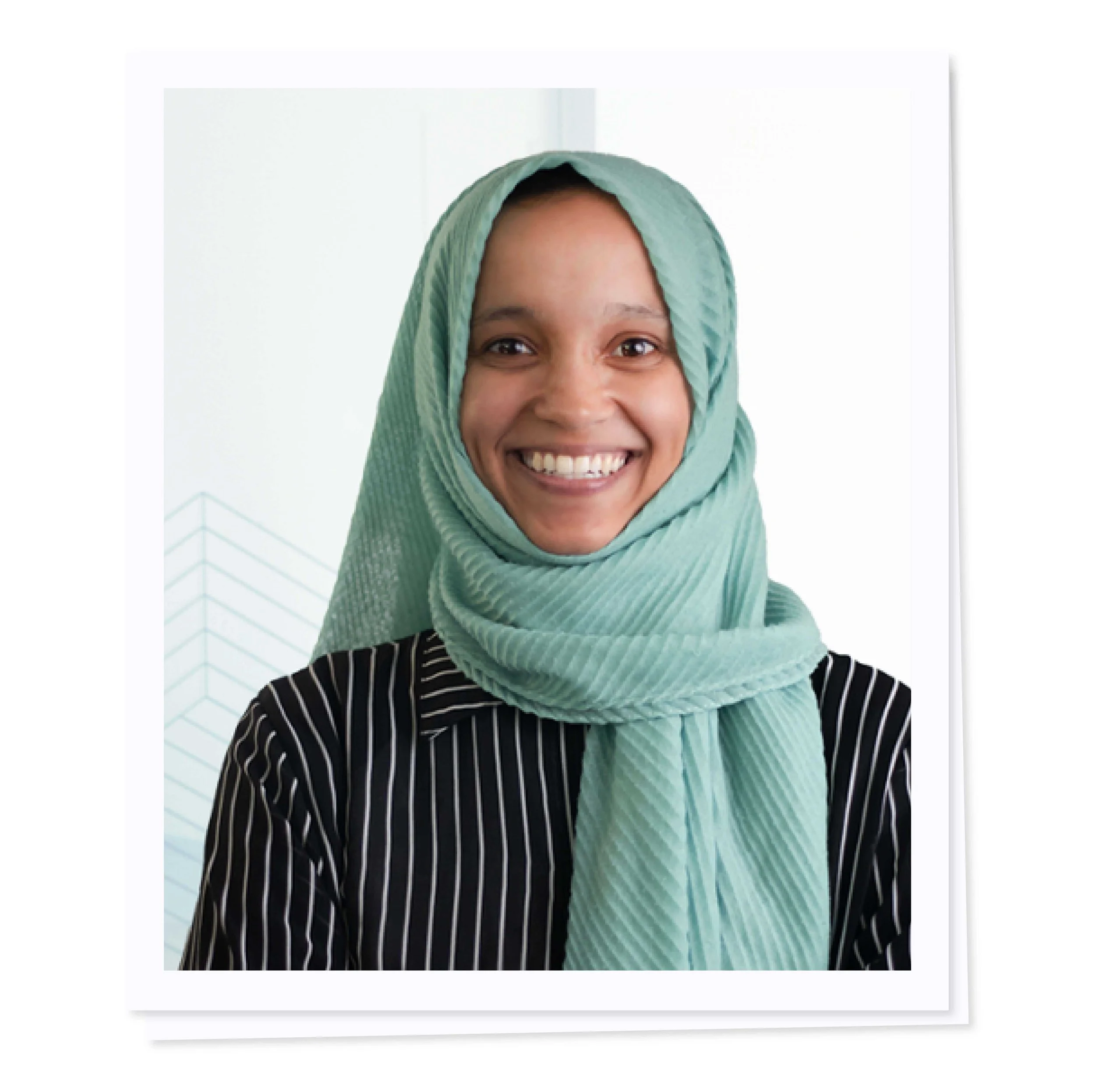 Smiling person wearing a light blue hijab and a black and white striped shirt.