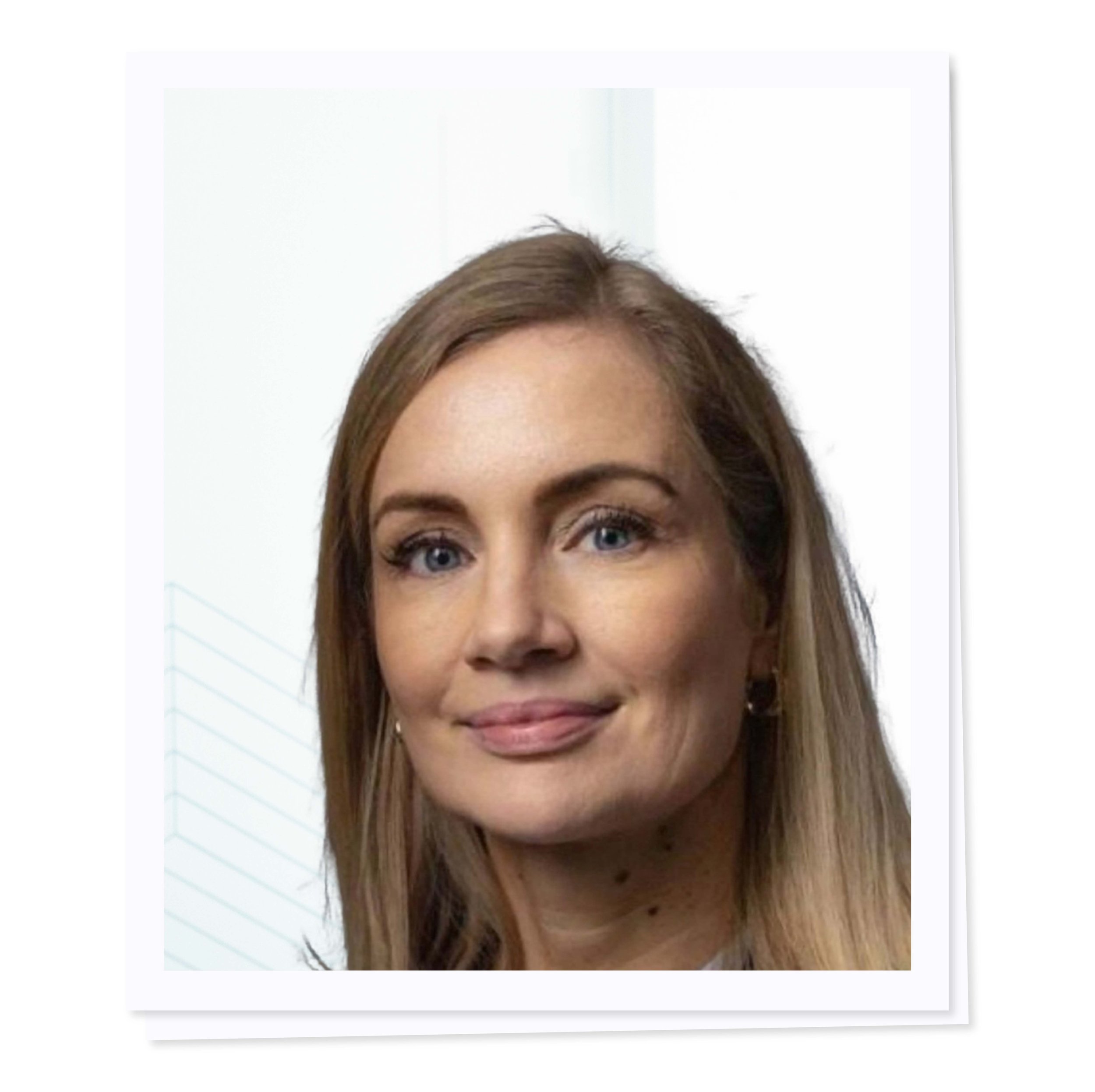Portrait of a woman with long blonde hair, smiling slightly, wearing earrings.