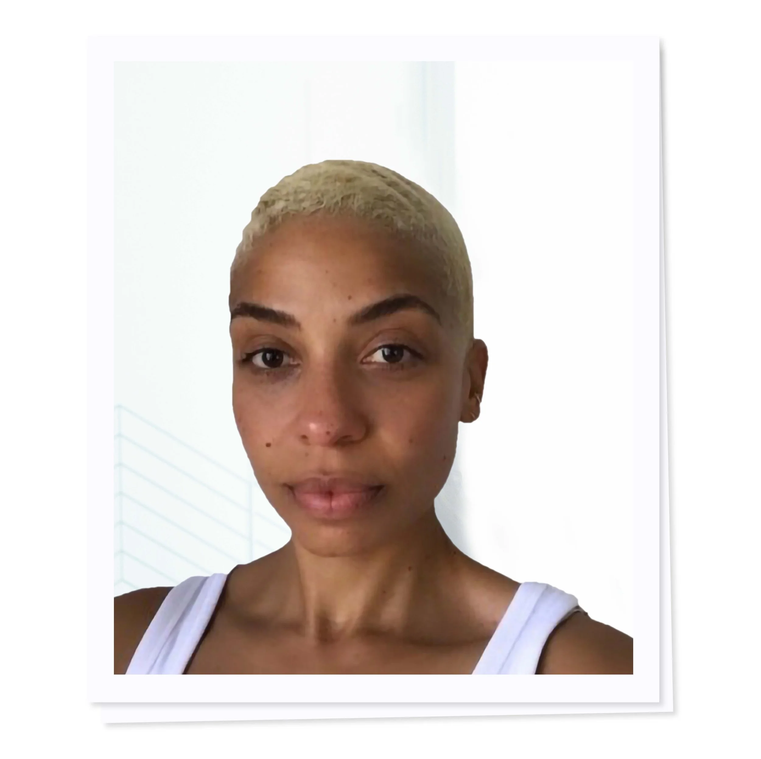 Portrait of a person with short blonde hair and a white tank top, against a white background.