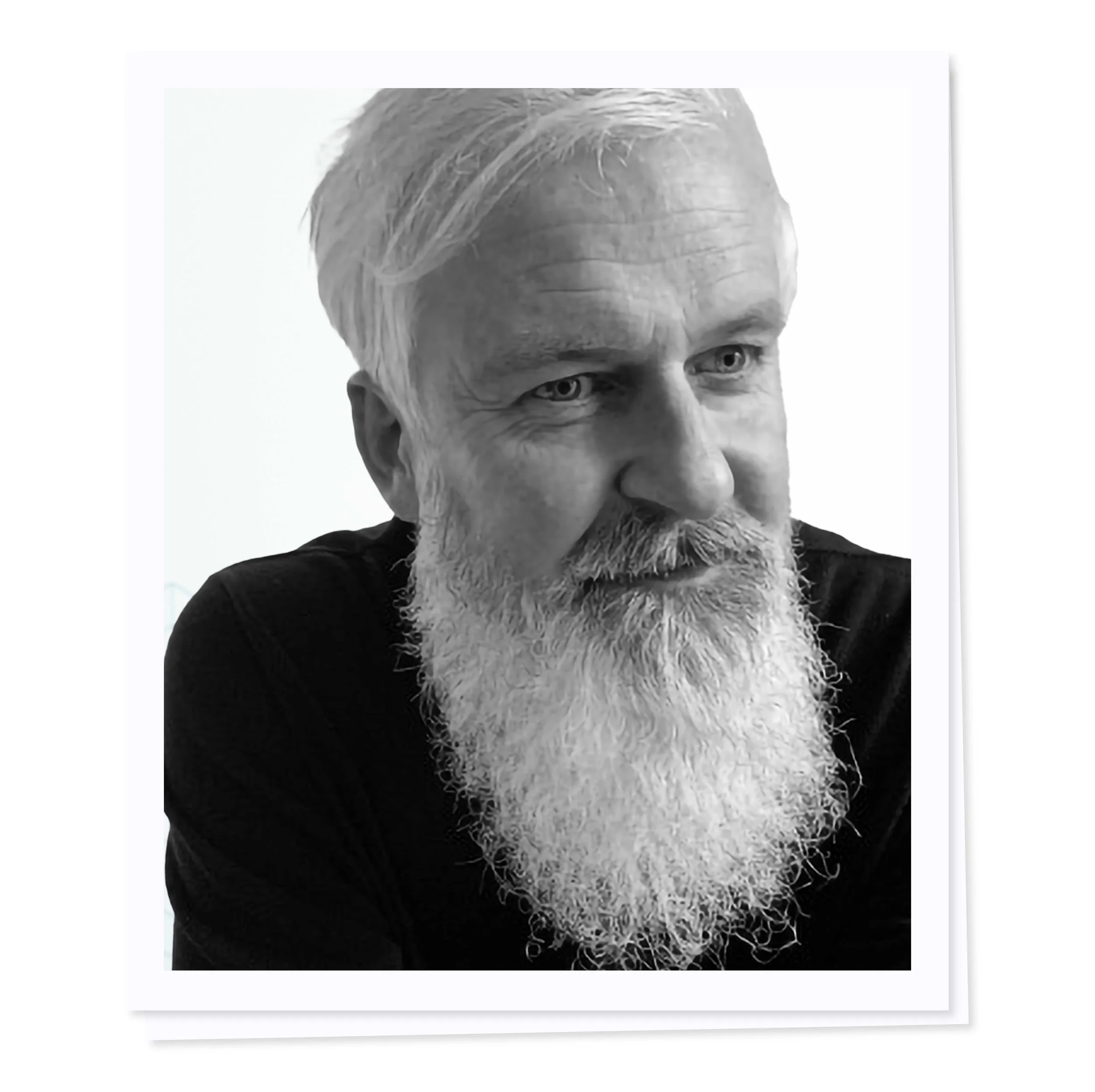 Black and white portrait of an older man with a white beard and dark clothing, looking to the side.