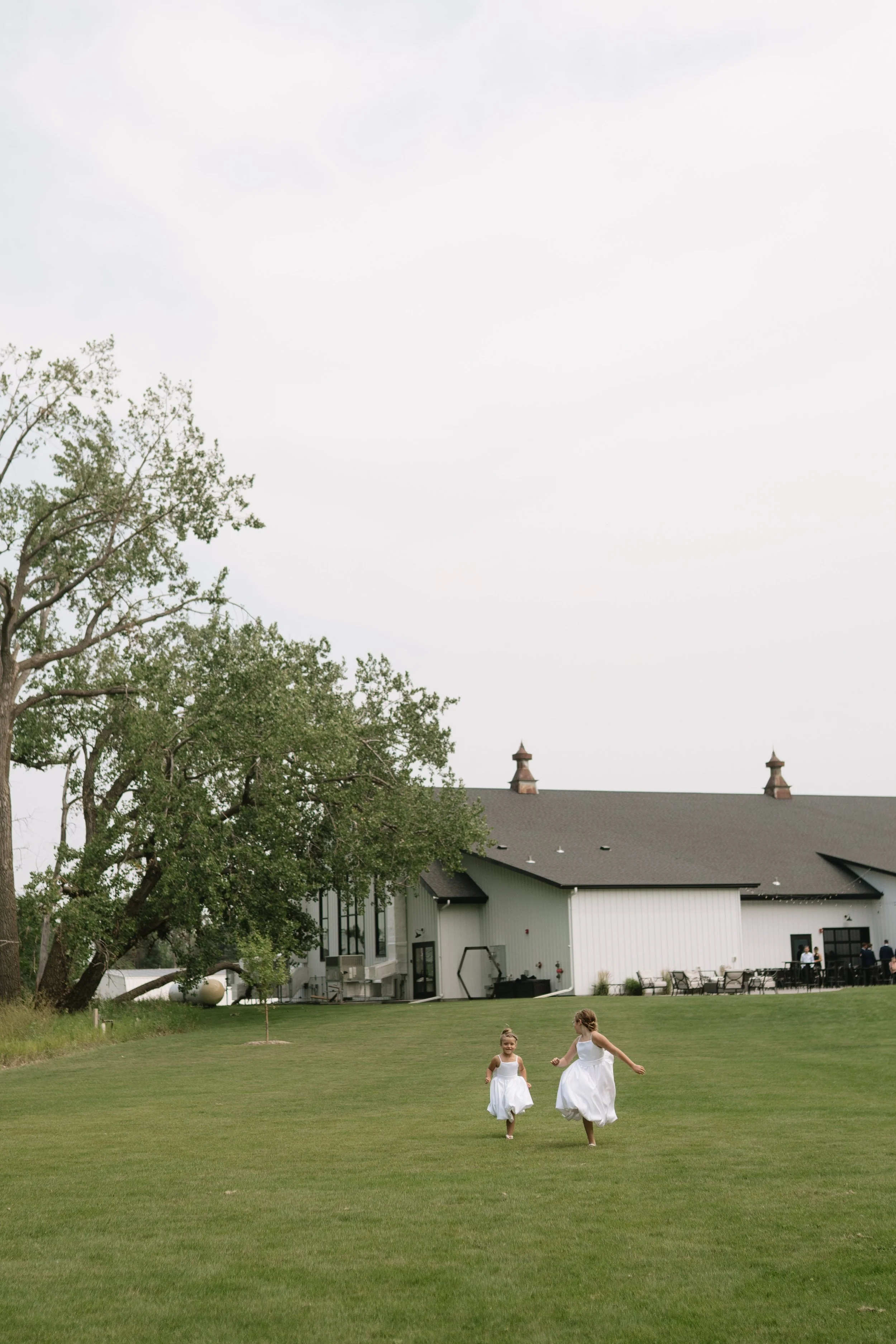 Fargo North Dakota outdoor family wedding photography session children running across lawn at Lone Oak venue Ayr North Dakota  at sunset by Aesthete Pix