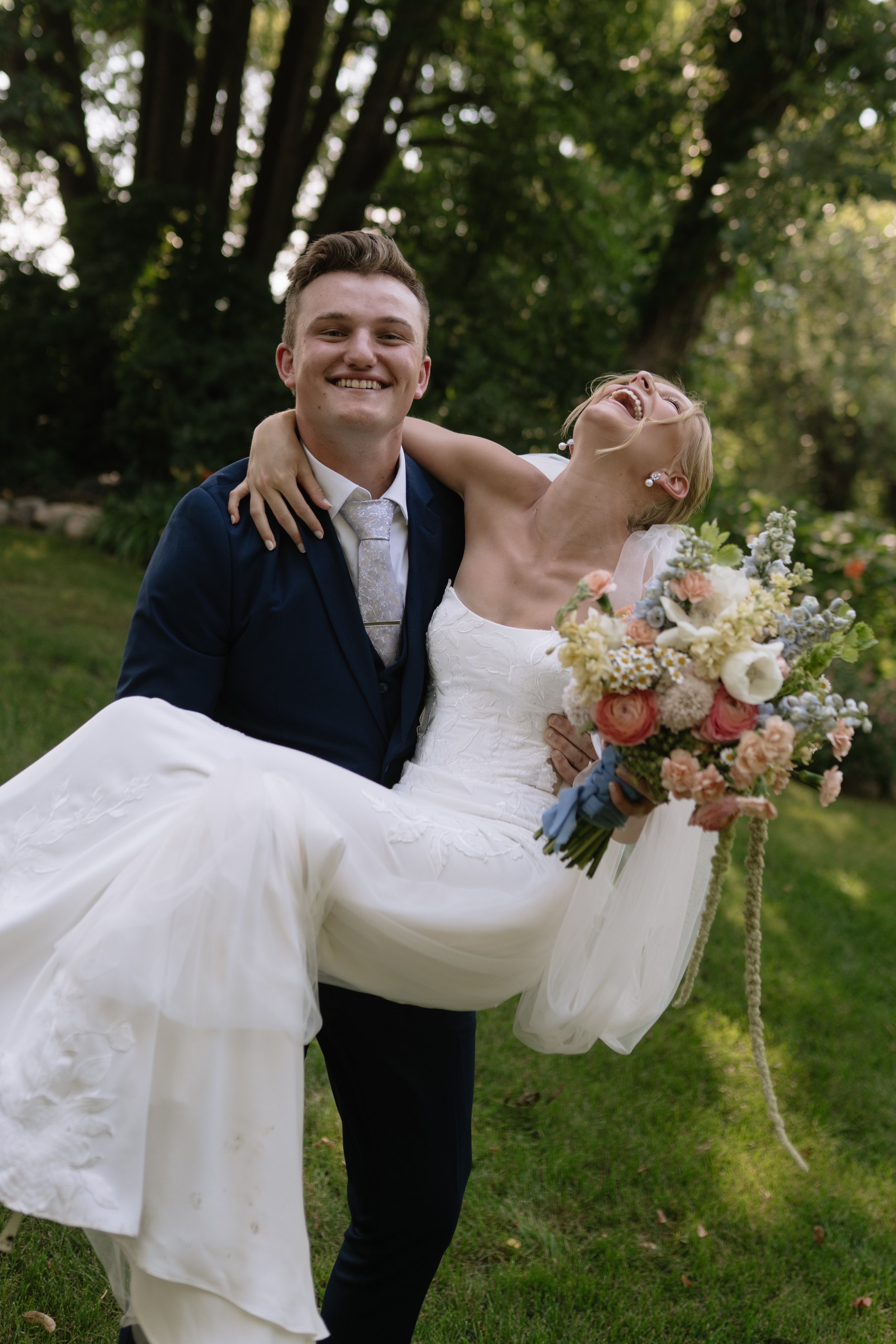 Detroit Lakes  Minnesota photographer at outdoor wedding couple portrait groom lifting bride by Aesthete Pix wedding photographer