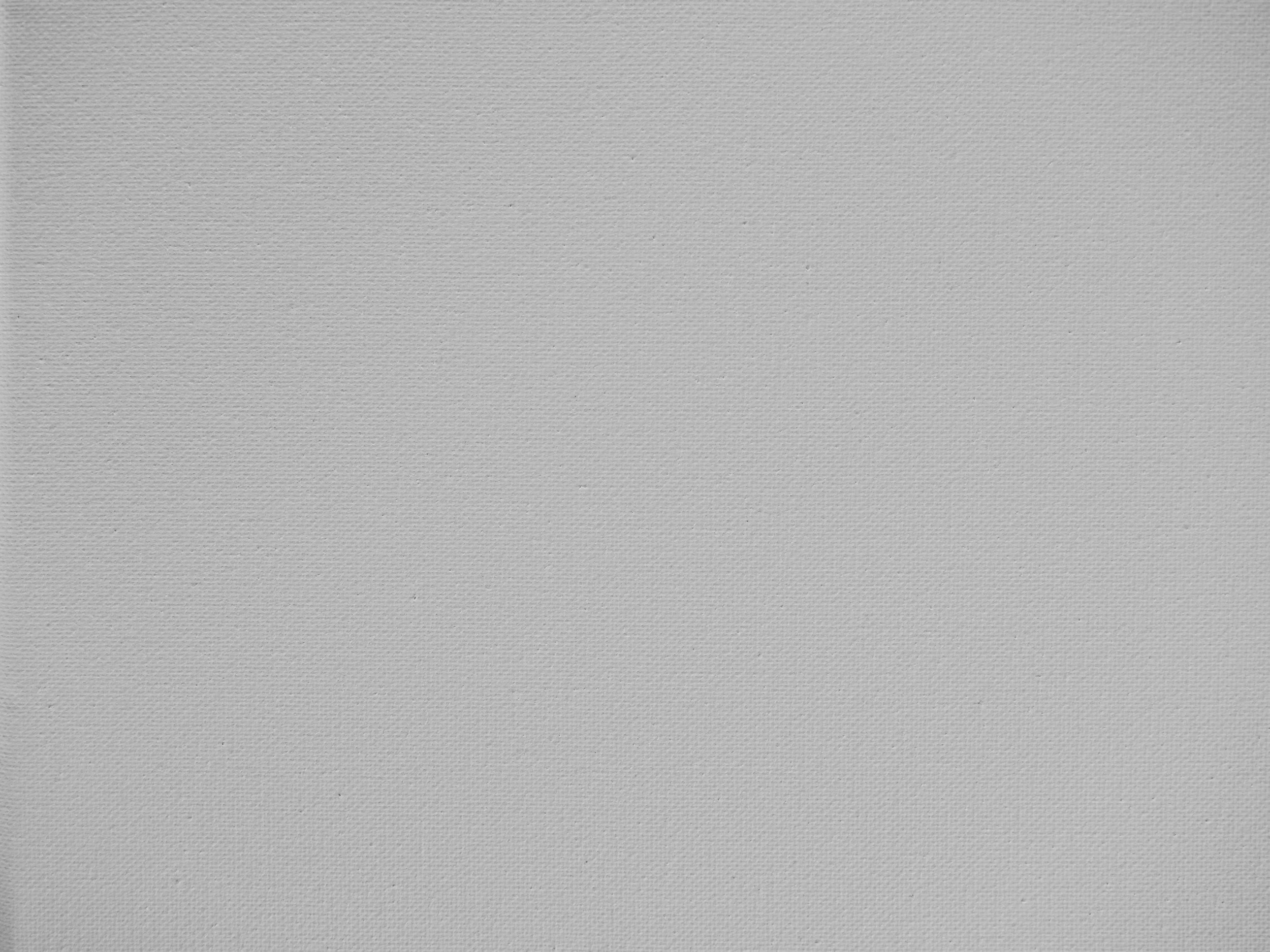 A textured surface resembling a light-colored fabric or paper with a subtle pattern.