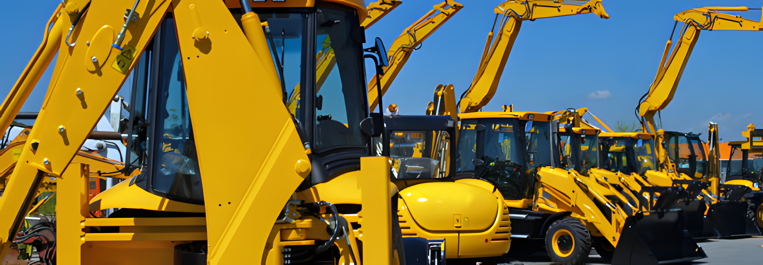 A lineup of multiple yellow construction excavators parked outdoors under a blue sky.
