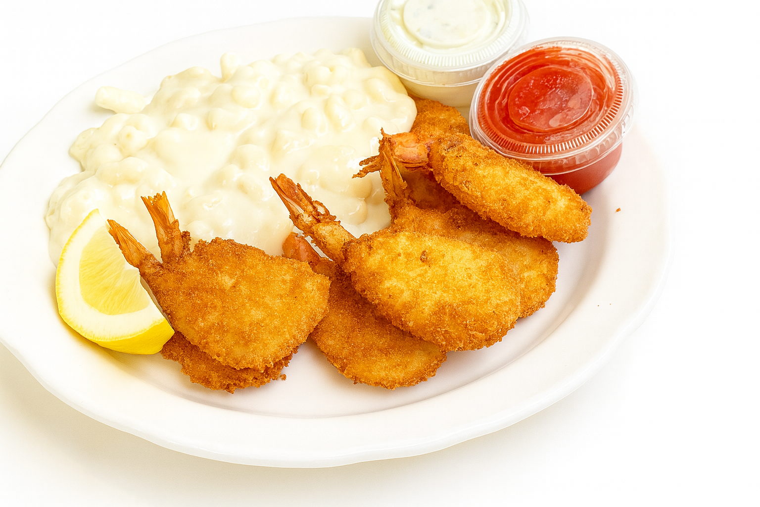 Plate of fried shrimp with two cups of cocktail sauce, a lemon wedge, and creamy coleslaw