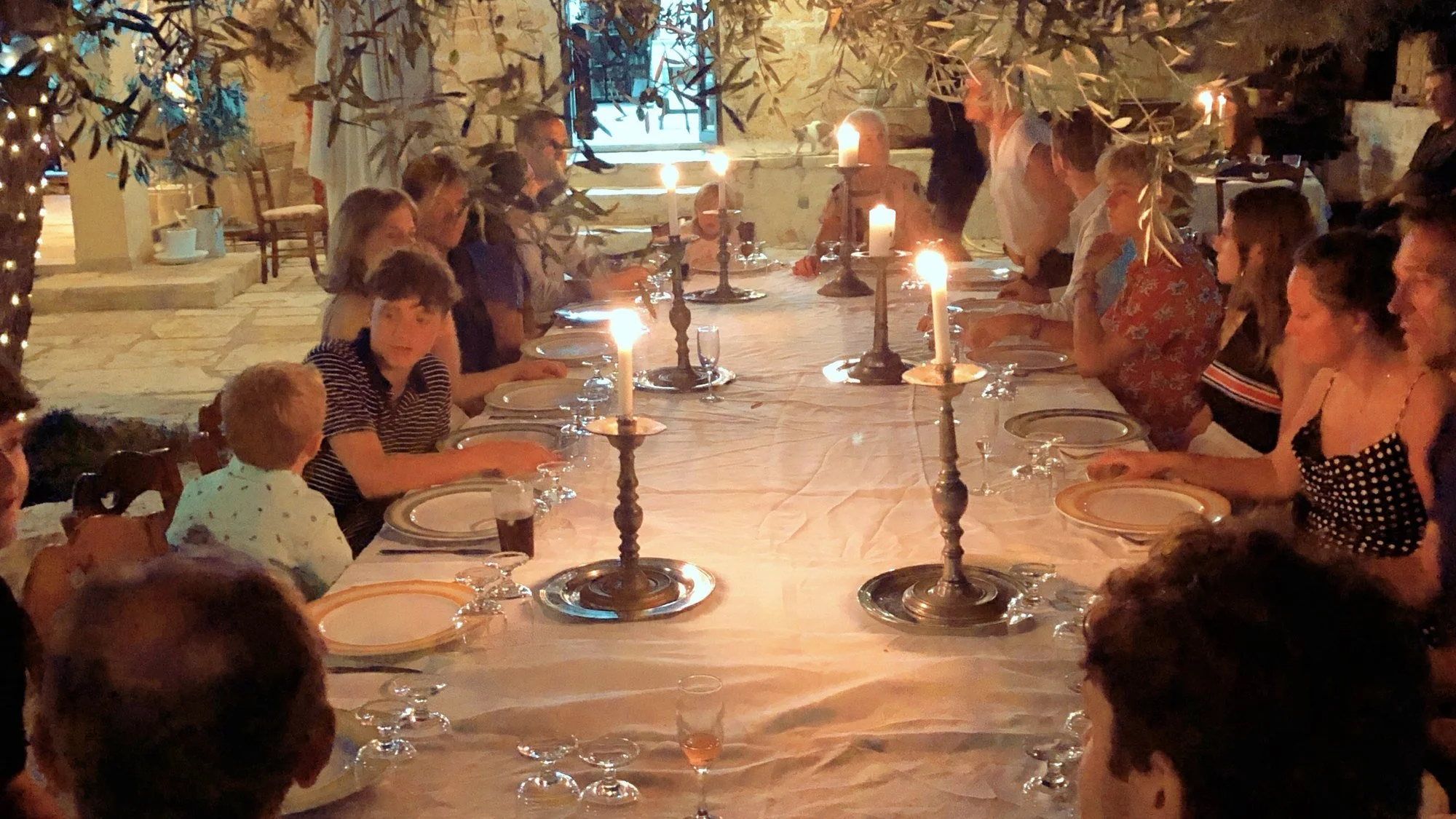 Guests at a long candlelit dinner table at Villa Cappelli
