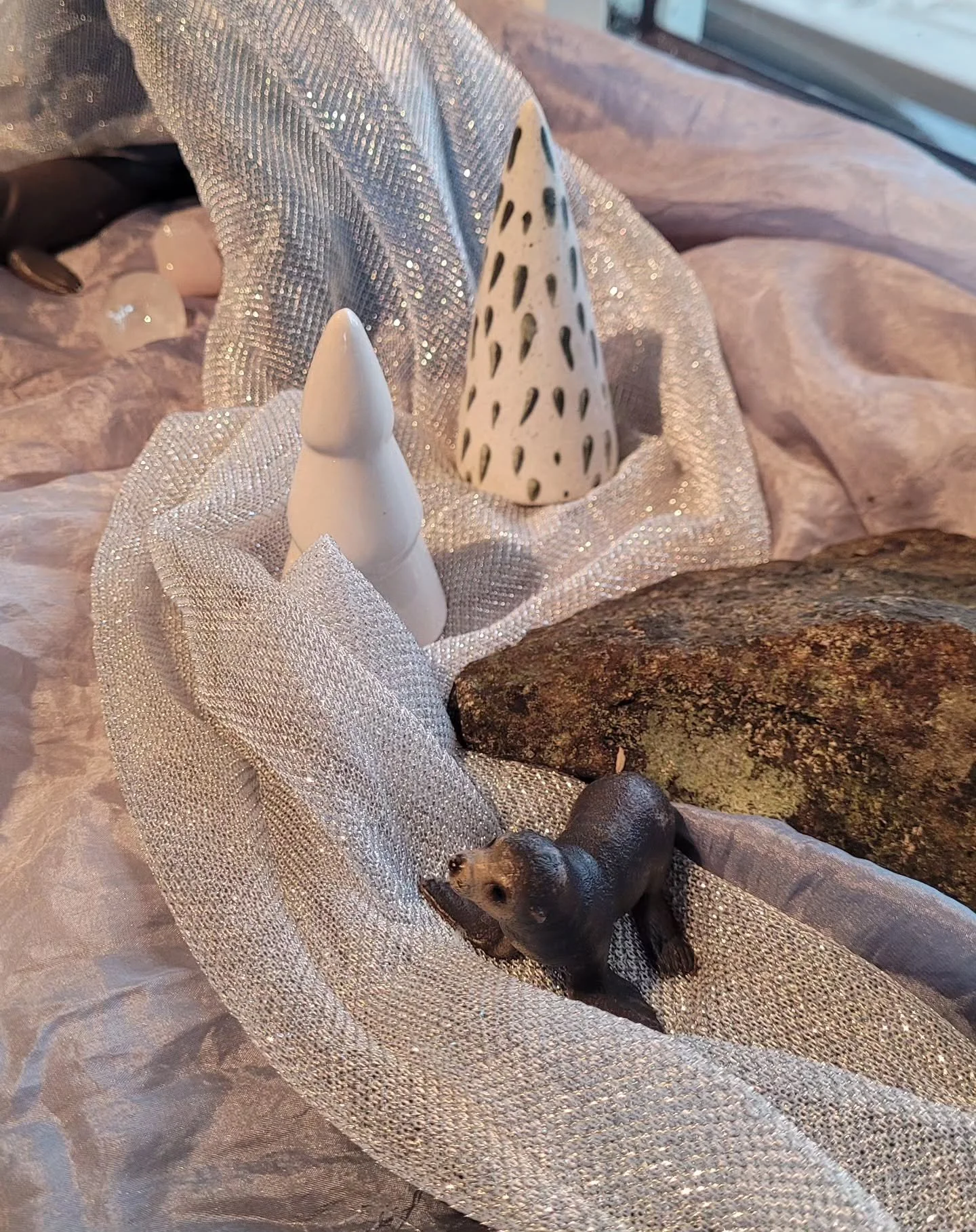 Vinter i vinduskarmen❄️ 

Dette &aring;rstidsbordet har:

🗻Lekesilken Stein fra Earth Collection @sarahssilks 

💎Lyse krystaller

🦭Solide lekedyr 

🪶Pinne og stor stein

🤎 Bro fra lekeregnbue

🌲 Pyntetr&aelig;r

❄️ En bit glitterstoff

Hva har 