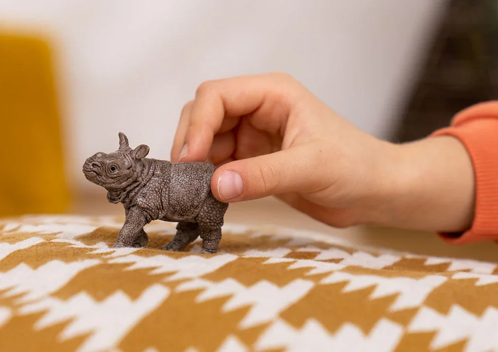 rhino schleich baby in hand.webp
