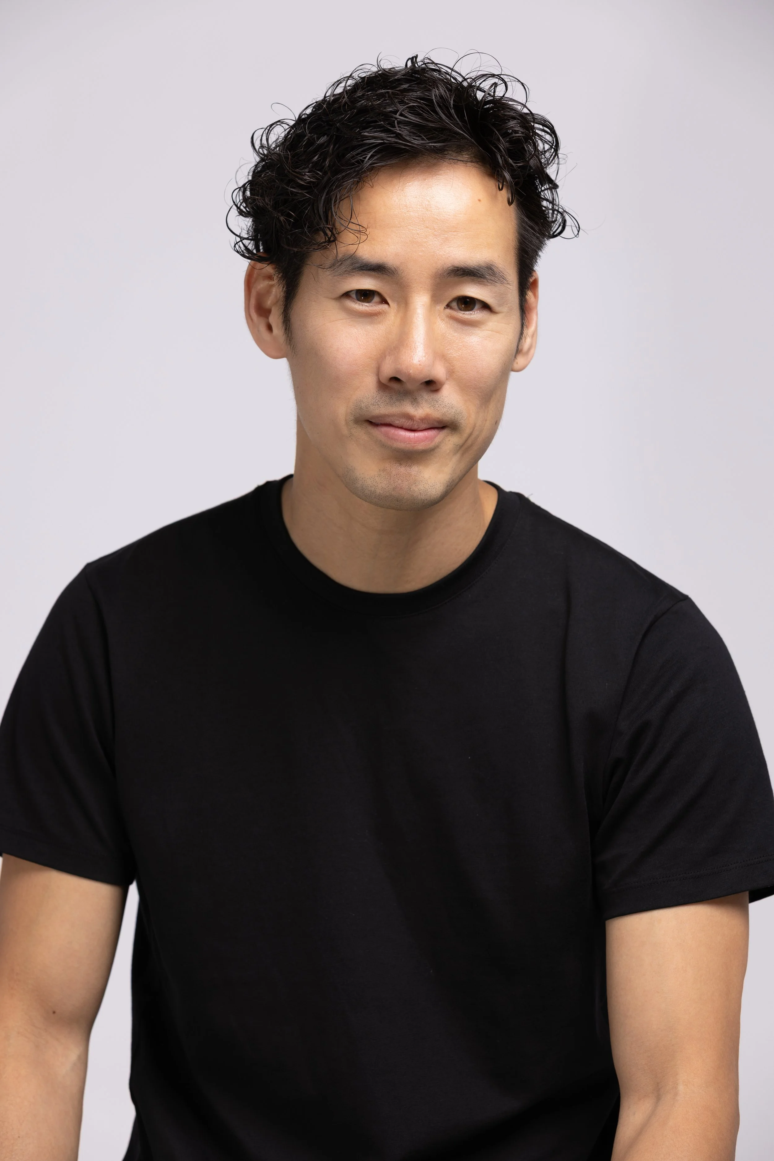Ray Yee in a black T-shirt, studio headshot