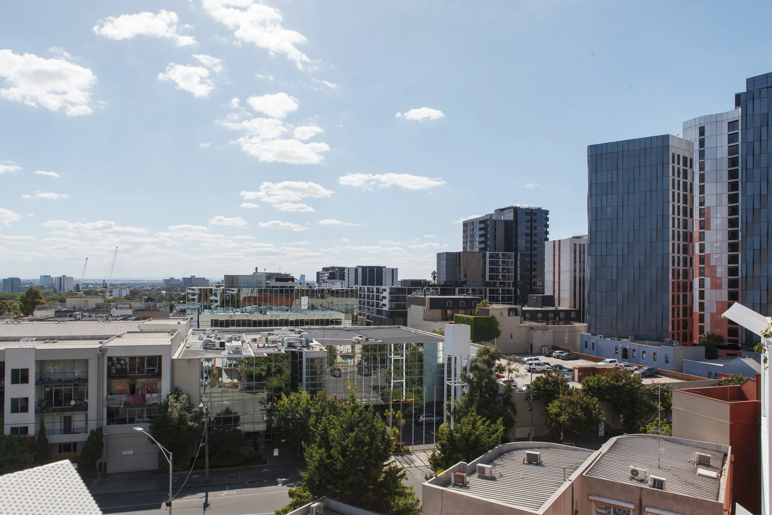 Cityscape view of modern buildings and skyscrapers under a partly cloudy sky