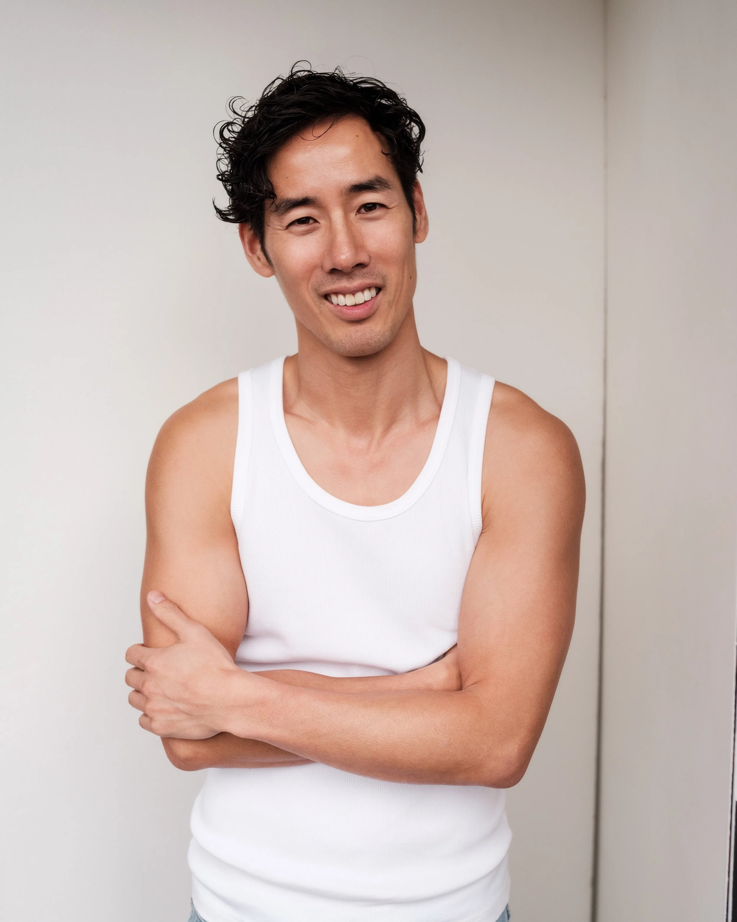 Ray Yee in a white singlet, front view, smiling, model digitals