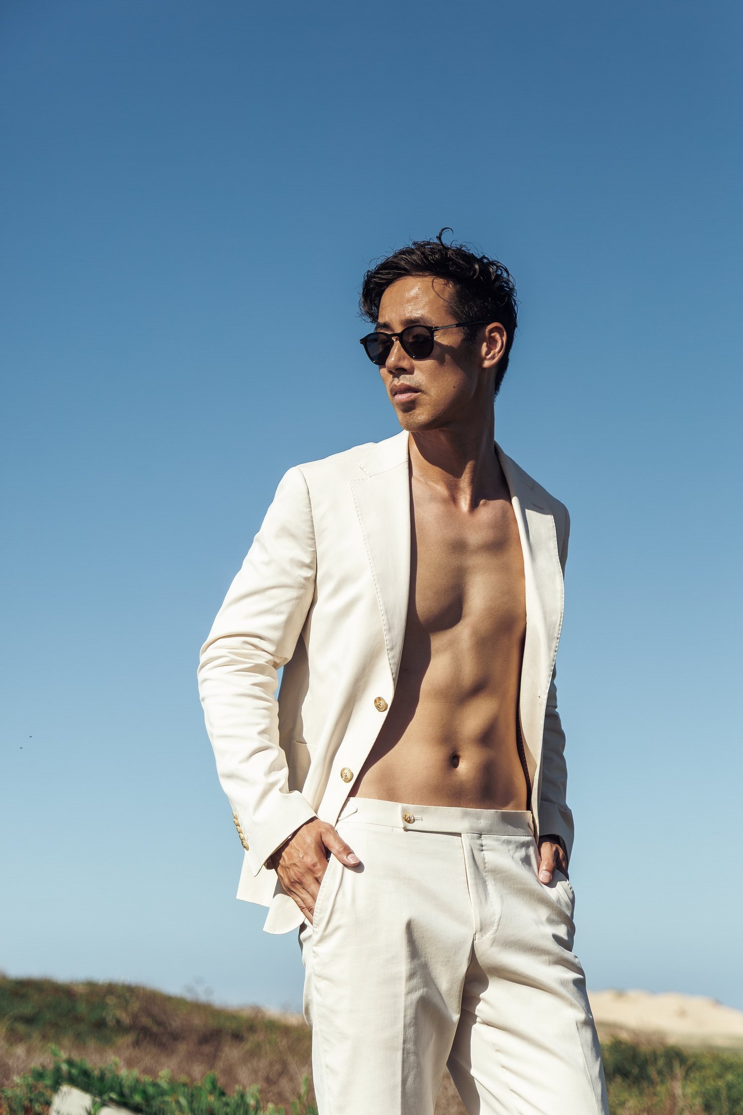 Ray Yee in a cream suit and sunglasses against a blue sky, Oxford Shop 2026