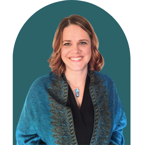 Smiling woman with shoulder-length hair wearing a blue jacket and necklace, against a teal background.