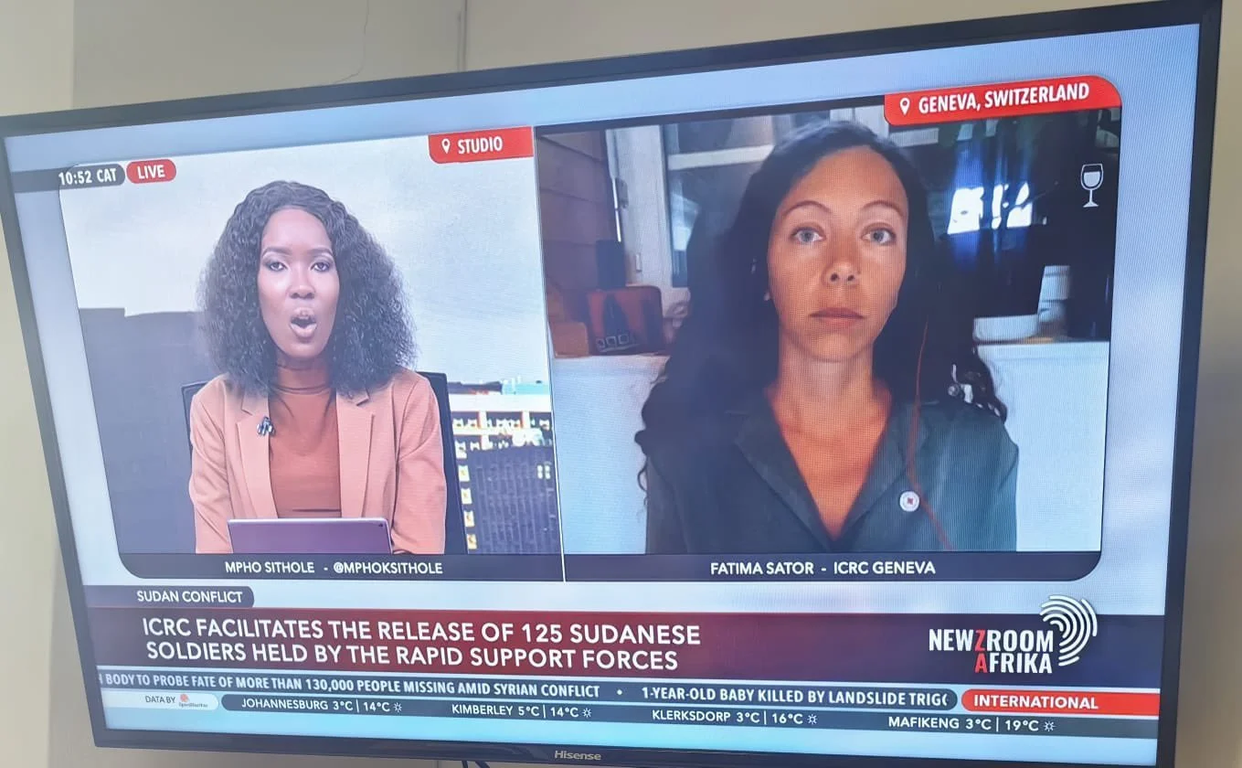 Television screen showing a news broadcast with two women, one in a studio and the other in Geneva, Switzerland, discussing Sudan conflict and the release of Sudanese soldiers.