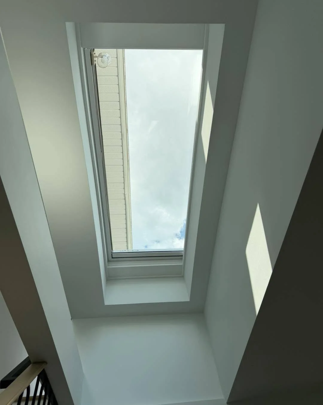 Finished skylight installation with interior trim and solar-powered blind