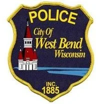 Police badge for the City of West Bend, Wisconsin, featuring a church and the year 1885.