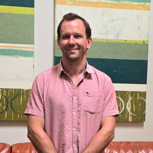 A smiling man standing in the lobby of Midtown Psychotherapy Associates in Atlanta, Georgia.