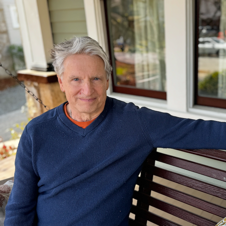 Peter Plishka sits on a wooden bench on a porch outside