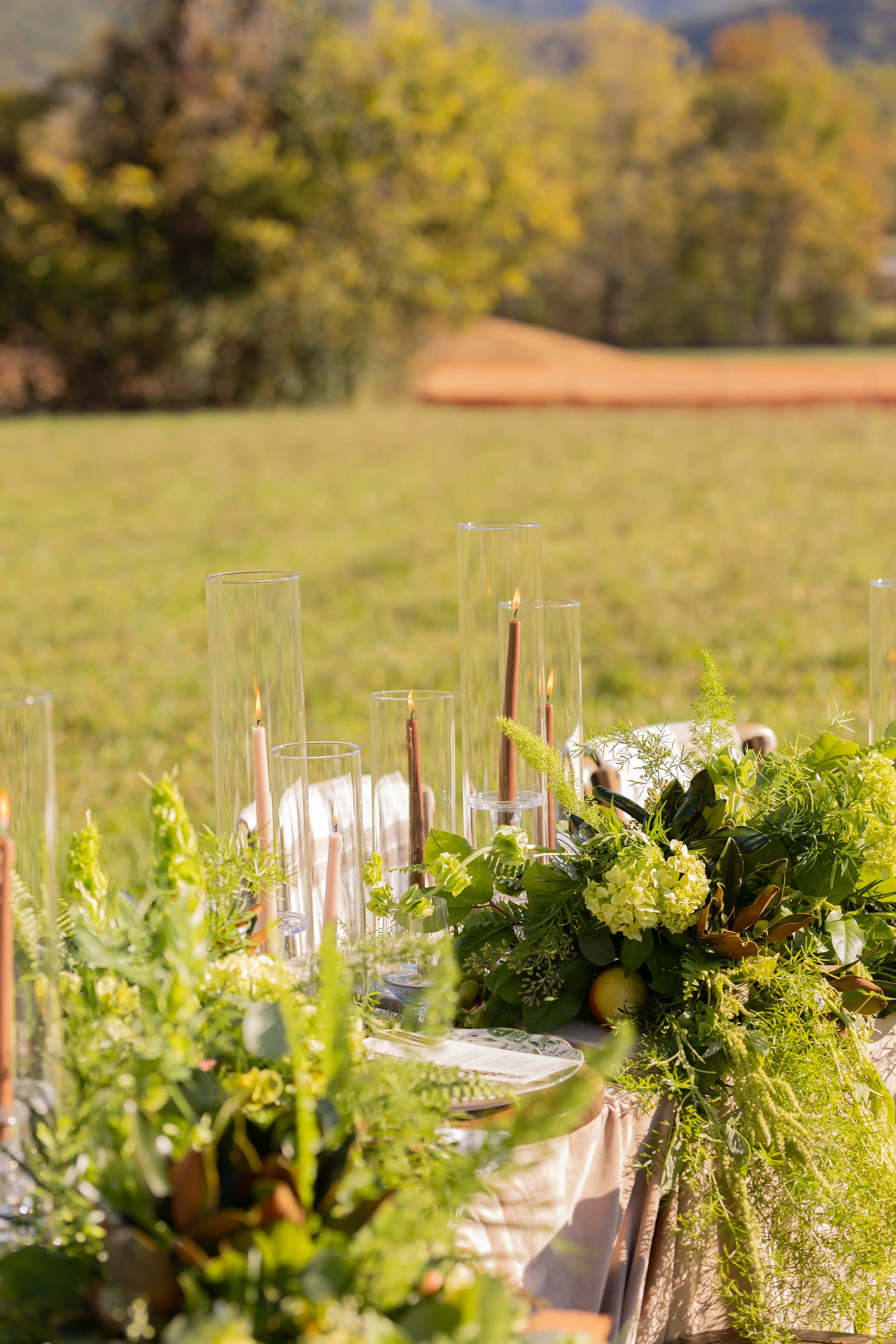 Fall wedding table decorated with lush greenery, seasonal florals, and taper candles at a Smoky Mountain wedding venue near Gatlinburg.