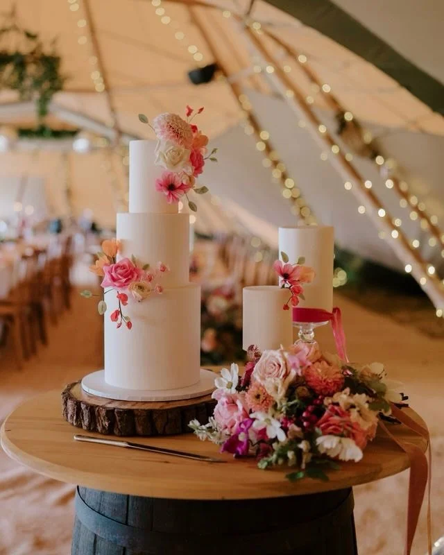 Why have one wedding cake, when you can have 3. 

How beautiful does this set up look with 2 smaller wedding cakes complimenting the main cake. Decorated with a variety of vibrant sugar flowers and silk ribbon. 

This trio of wedding cakes not only m