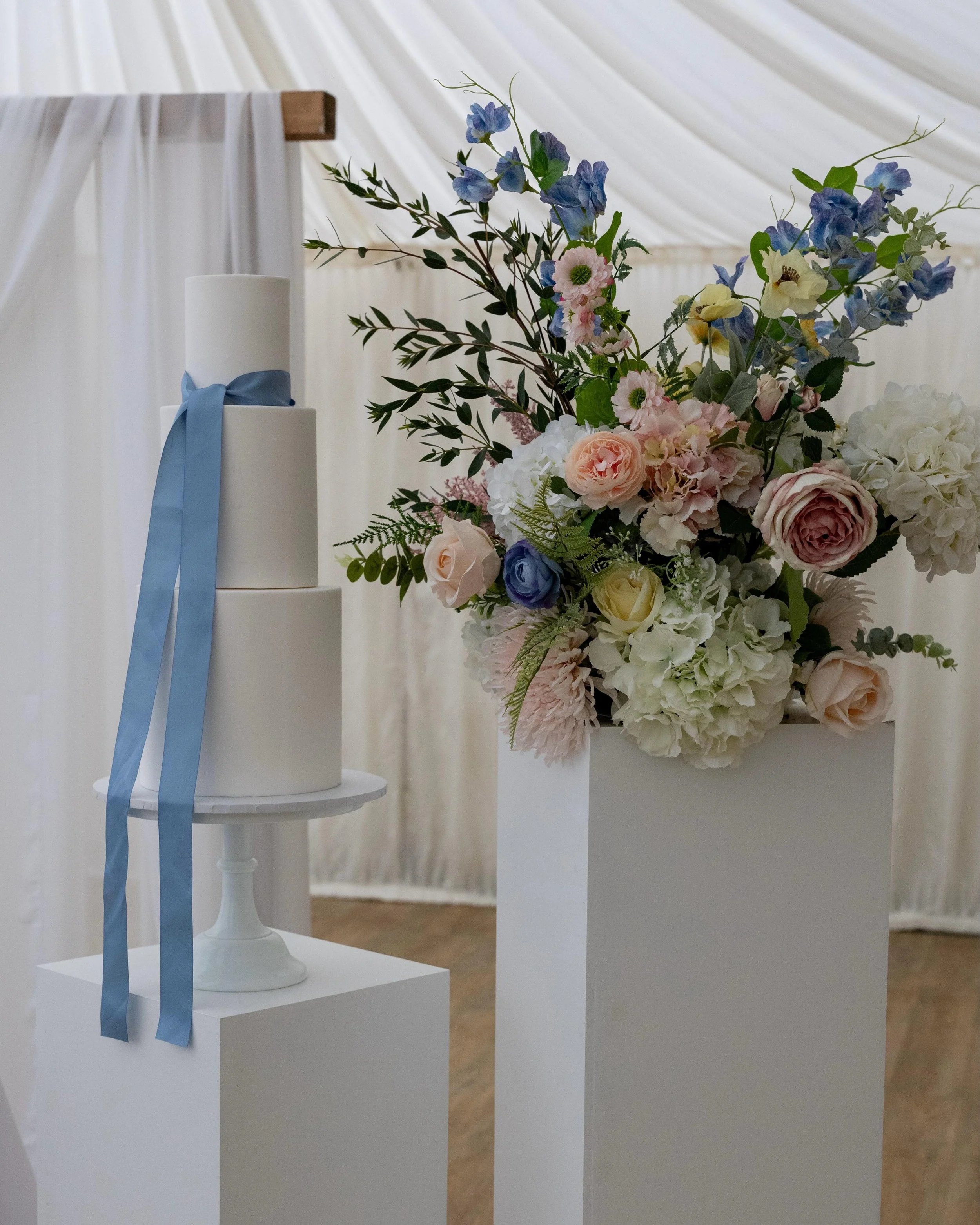Such a beautiful set up with the most gorgeous pastel tones and flowers.
The perfect backdrop for this all white 3-tier wedding cake. The only decoration required to compete it is a satin ribbon 🩵 

Suppliers 
Venue: @hargatehall
Venue stylist &amp;