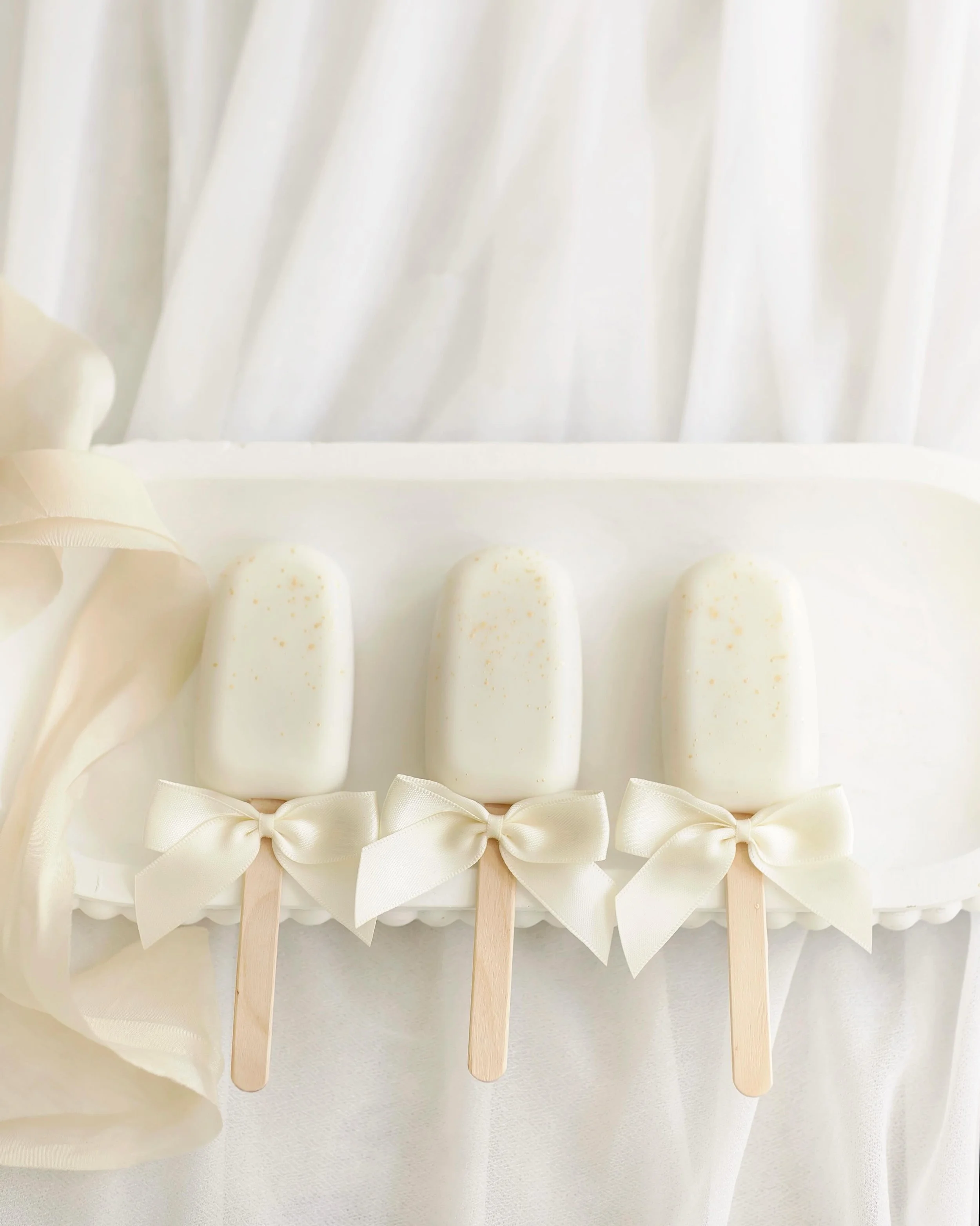 Cakesicles are a perfect addition to your celebration. 

Delicious sponge encased in finest Belgium white chocolate with bespoke decoration to complement your occasion.

They are perfect as an addition to your wedding treat table, as a gift, within a