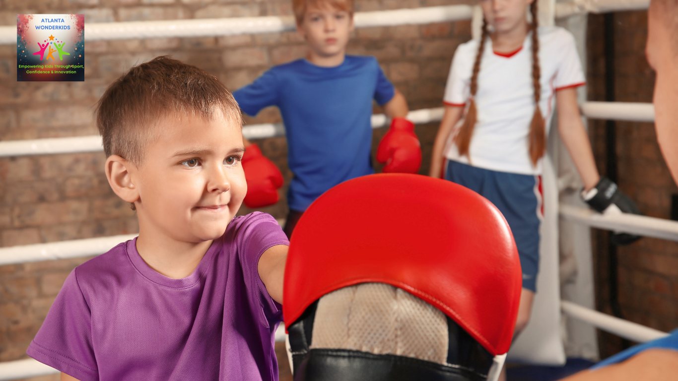 Young boy in a purple shirt practicing boxing with a trainer in a gym, wearing red boxing gloves, with other children in the background.