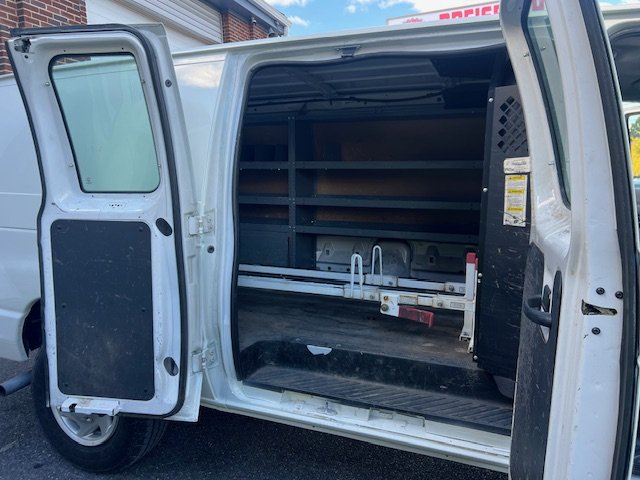 Interior of a white cargo van with shelves and equipment for deliveries or service work