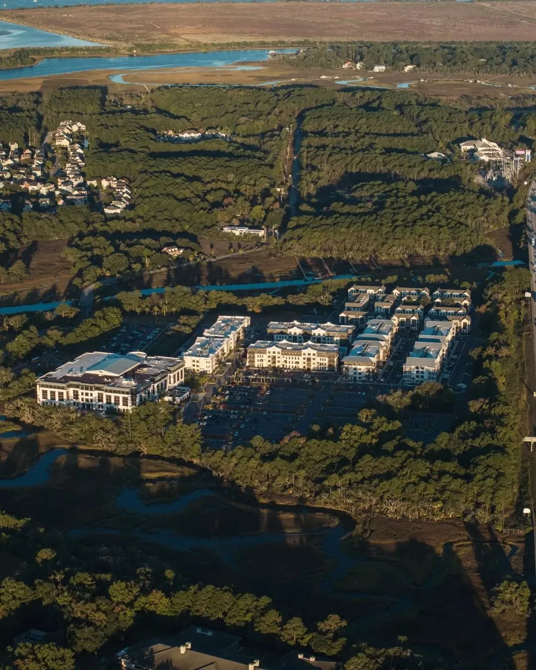 A sweeping view of Nowell Creek Village &mdash; where woodland, waterways, and thoughtfully designed spaces come together. From this height, you can see just how naturally the community settles into the landscape, surrounded by marsh paths and moment