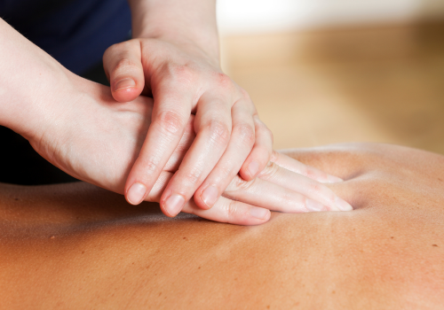 Person performing CPR on a person lying face down.