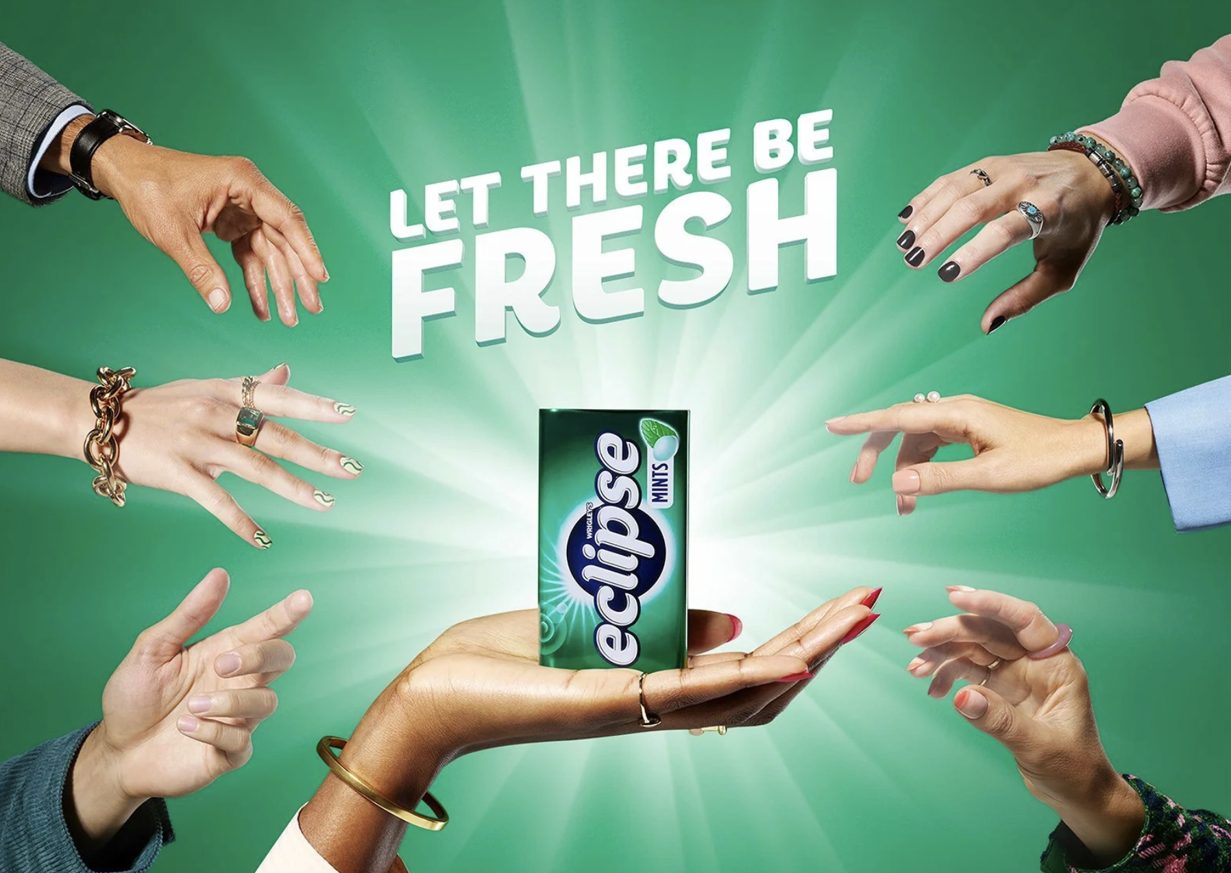Multiple hands of diverse women holding a pack of Extra peppermint gum with the phrase 'Let there be fresh' in the background.