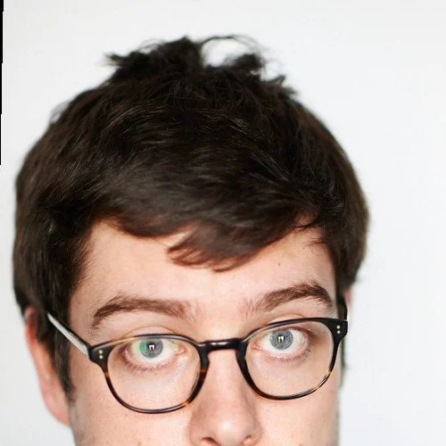 Close-up of a person's face with glasses, showing only their eyes and forehead.